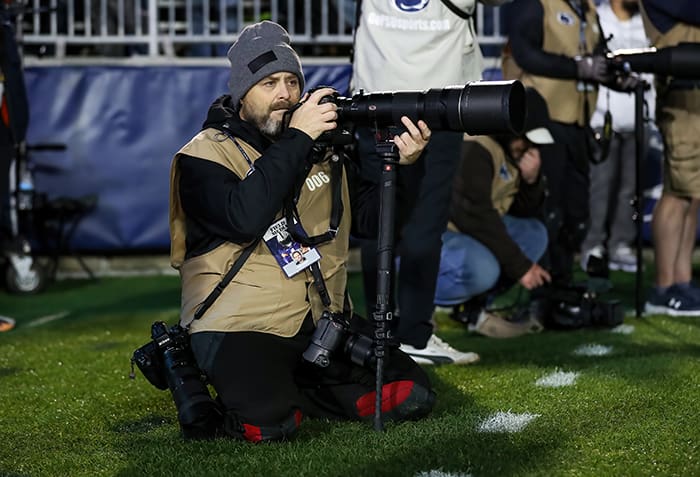 Barry holding ccamera on football field